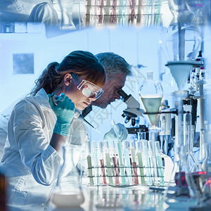 在生命科学实验室工作的医疗保健研究人员年轻女研究科学家和高级男主管在研究实验室准备和分析背景图片