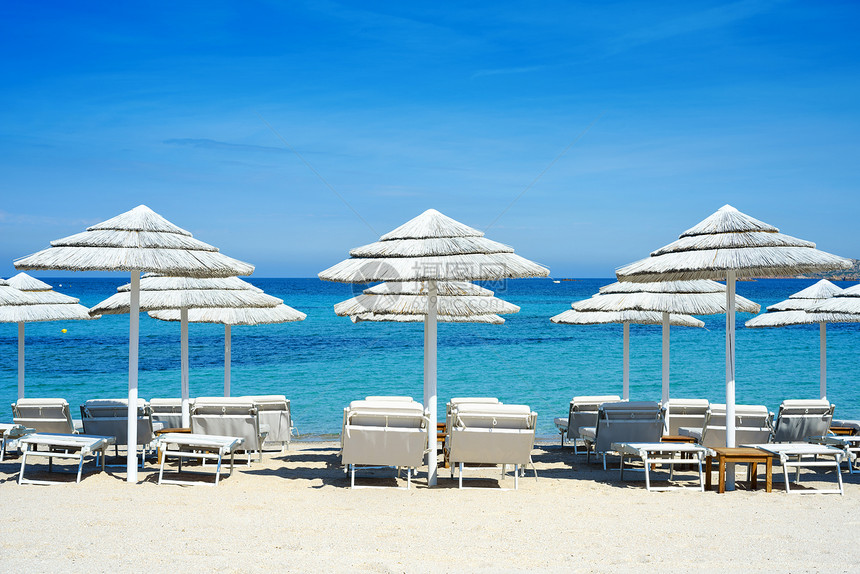 撒丁岛地中海滩上的白色雨伞图片