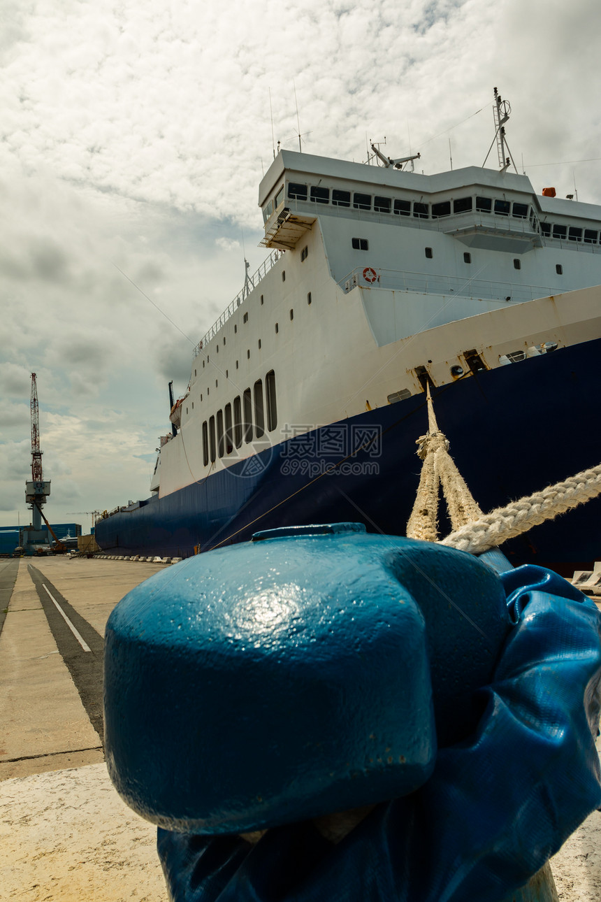 货船的弓和绳子被绑在Pier和Crane的BlueB图片