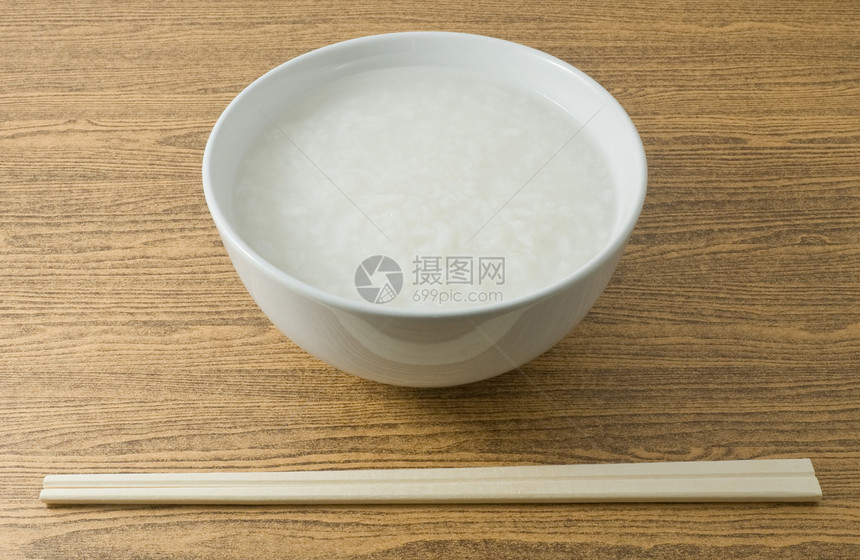 亚洲传统食品一碗亚洲大米粥或用竹棒图片
