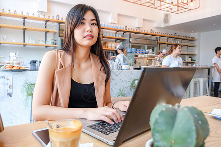 现代咖啡店使用笔记本电脑的亚洲商业妇女临时图片