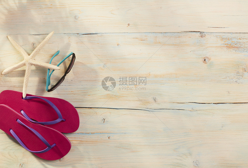 木板上的拖鞋和太阳镜图片