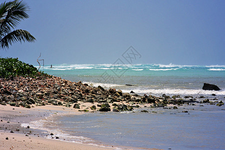 塞班岛加拉班的白色沙滩上的岩石为这个北马里亚纳群岛的热门海滩目的地图片