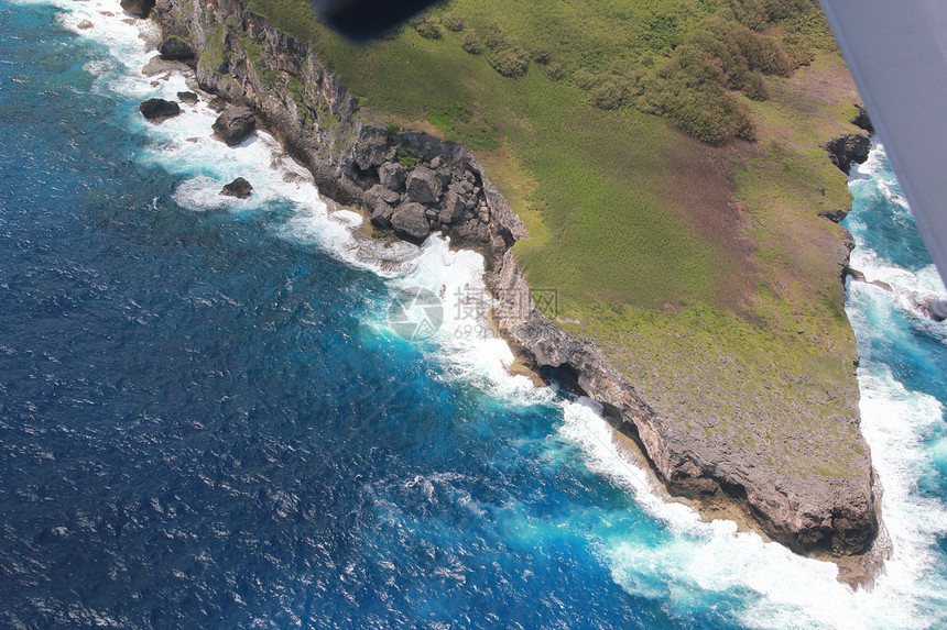 巨大的海浪拍打着陡峭悬崖下的尖锐岩石图片