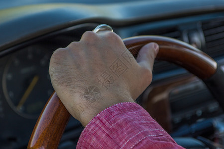 男人的手放在车内的方向盘上图片