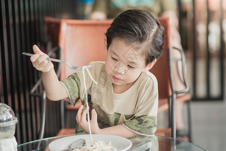 亚洲可爱的辣妹在餐厅吃意大利面条卡宝拉SpaghettiCarb图片