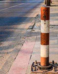 红色和白色的工业金属街杆在混凝土足迹上连接在一起图片