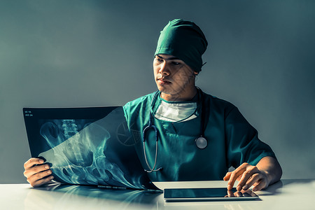 男医生或外科医生在黑暗房间使用平板电脑时图片