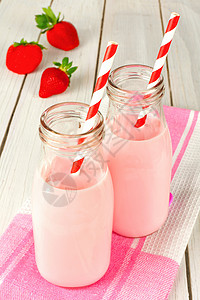 传统瓶子中的草莓牛奶白图片