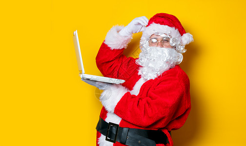 有趣的圣诞老人有一个乐趣与笔记本电脑图片