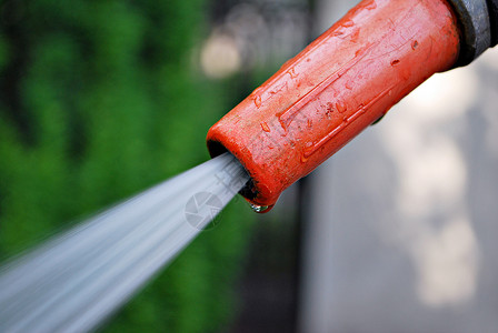 用水罐给花园浇水将喷水管装在灌溉植物上图片