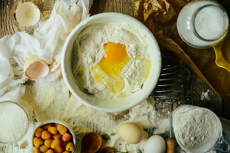 烘烤羊角面包的配料面粉木勺擀面杖鸡蛋黄油在木图片