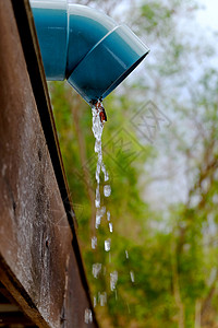 水从屋顶雨水槽落水管倾泻而下图片