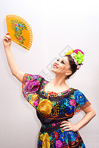 身着传统墨西哥连衣裙带扇子的美丽微高清图片