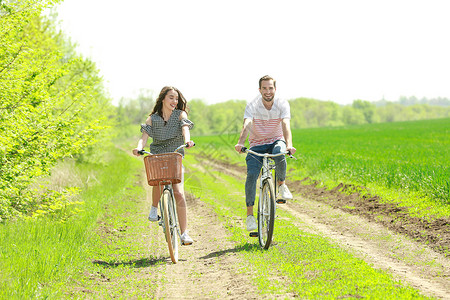 快乐的年轻夫妇在农村骑自行车图片