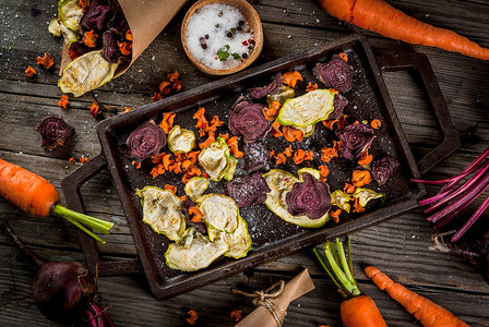 有机食品纯素饮食干菜由甜菜胡萝卜和西葫芦制成的自制薯条在旧木质朴的桌子上背景图片