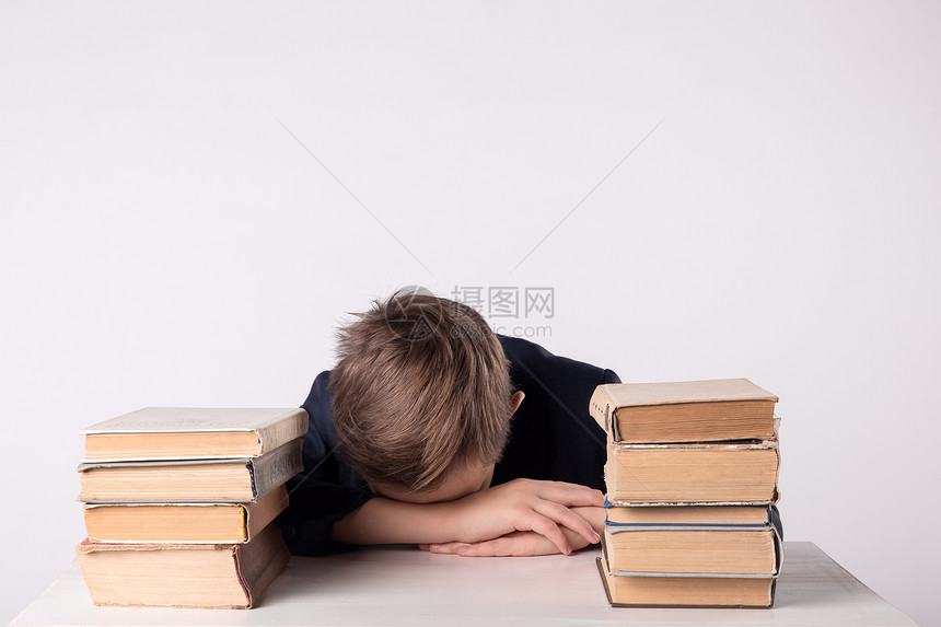 一个小学年龄的孩子做作业男孩在家里的办公桌上做作业学生上课很无聊男孩在做作业时睡着了可爱图片