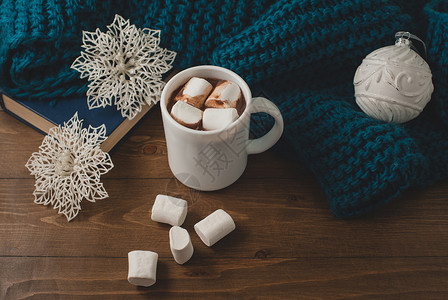 舒适的冬季家庭背景一杯热可加棉花糖圣诞球雪花和温暖的蓝色针织毛衣图片