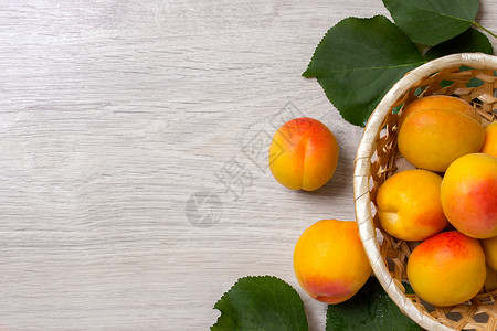 篮子里的新鲜杏子在木桌上图片
