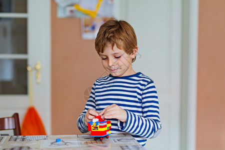 金发小男孩在室内玩很多彩色小塑料块背景图片