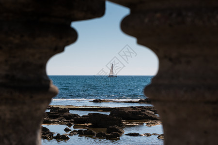 海滨附近的白帆船帆船从岩图片