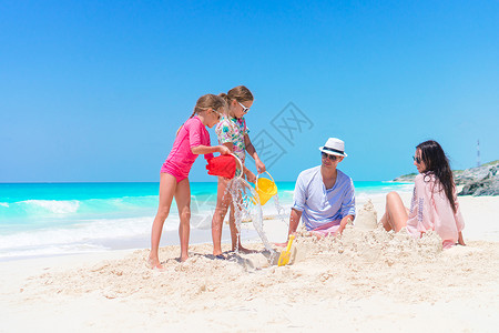 家庭在热带白色海滩图片