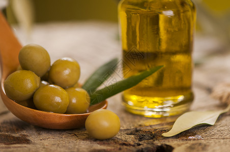 木桌上的橄榄油和橄榄枝图片
