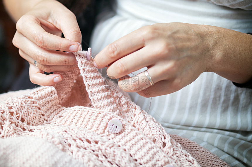 在手工制作的粉色针织毛衣上缝了一图片