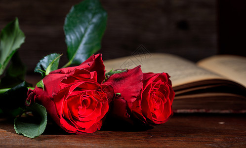 复古书和木制des上的红玫瑰图片