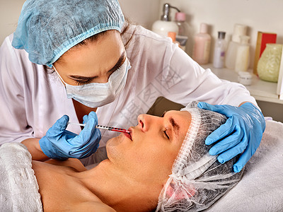男前额面部填充剂注射美容诊所的整形美容面部手术整容用注射器注射鼻唇沟药物的医用手图片