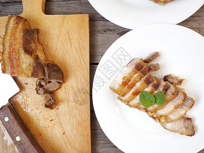厨房切菜板和餐盘上的烤猪肉肚图片