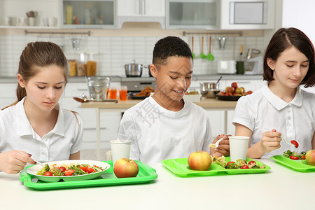 儿童在午餐时坐在学校食堂图片