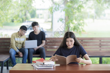 美丽的女大学生坐在礼堂里开心地笑着读书图片