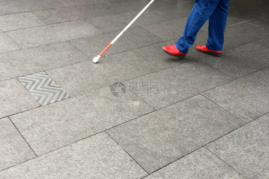 视力受损者用长的白拐杖棍在图片