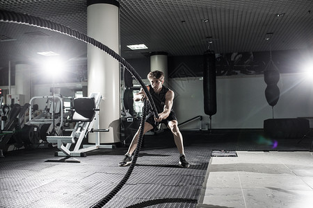 有吸引力的肌肉人用重绳子工作身穿运动服的英背景图片
