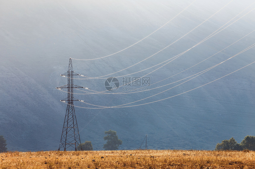 山或背景中的高压线和电力塔图片