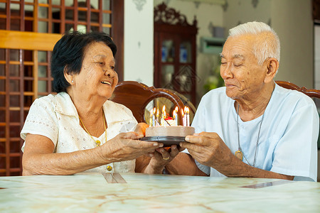 亚洲高龄夫妇在客厅里拿图片