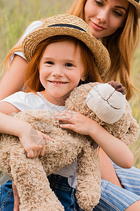 带着泰迪熊的美丽的快乐母亲和女儿图片