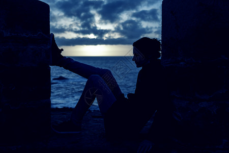 一位年轻女子的休眠感想日落时坐在图片