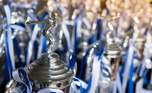 奖杯奖为背景为学校中的冠军领导而颁发的奖杯蓝色背景上的图片