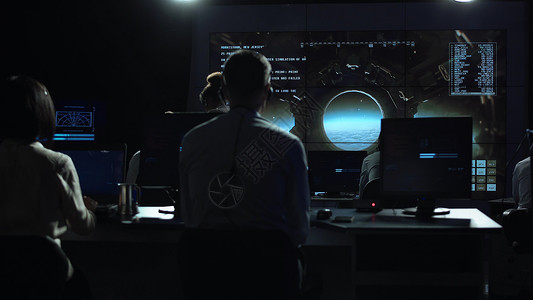 在飞行任务控制中心工作和管理飞行的人后视图航天器降落在月图片