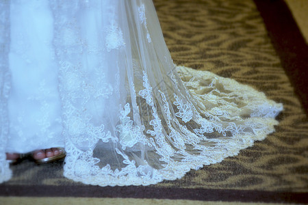 穿着白色婚纱的黑白礼服紧跟在地毯上新图片
