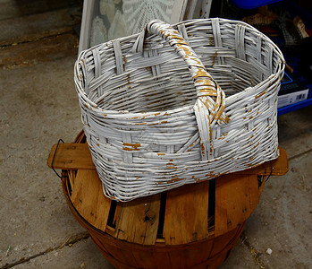 柳条篮白色油漆剥落放在圆形木桶上图片