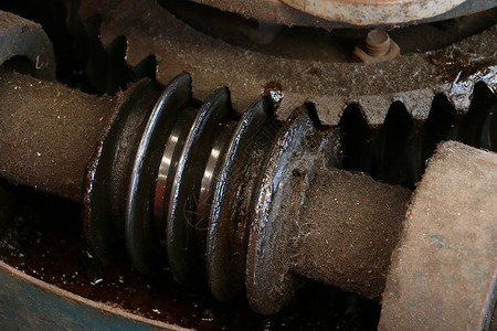 背景的生锈的老式正齿轮和蜗轮传动装置的特写详细的带蜗轮工业背景特写的图片