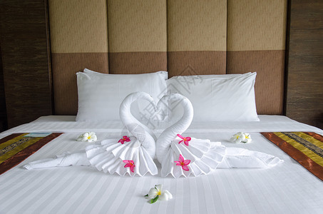卧室内床上的天鹅毛巾装饰背景图片