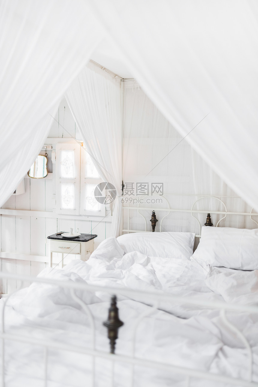 早上在浅色老式木制房间里的白色床白色内饰图片