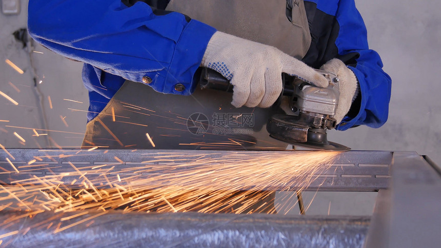 工厂钢结构电动砂轮磨削低速快门员工使用特殊的生产设备处理金属或铝打磨金属板的工人图片
