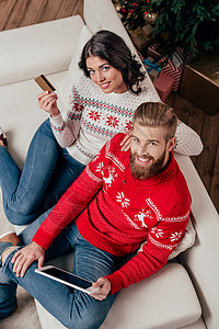 快乐的一对夫妇在圣诞节装饰房里用图片