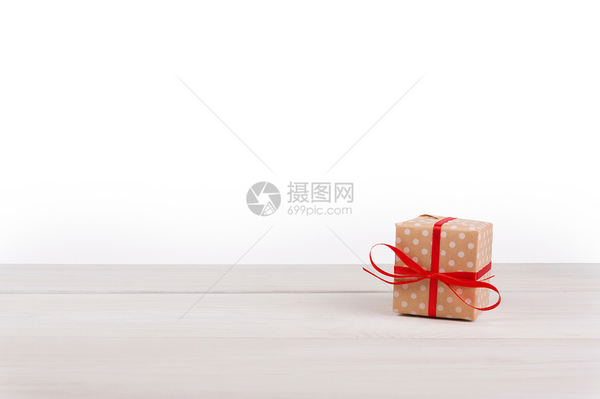 在白色背景的木头上用虚线纸和红色缎带包裹的礼品盒适合任何节日圣诞节情人节或生图片