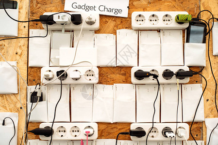 在人群活动讲座会议墙壁上为移动设备充电的插座背景图片